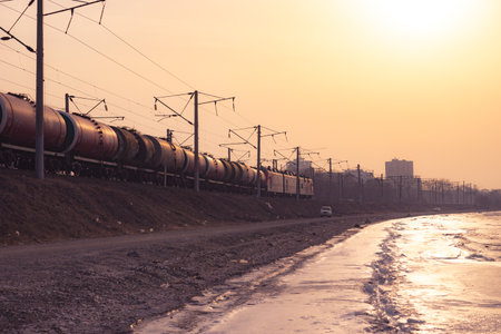 Seascape with a view of the icy coast in winter. On the railway moving train with tanks.の写真素材