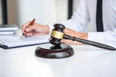 Businessman or lawyer working on a documents, judge gavel with Justice lawyers at law firm in...