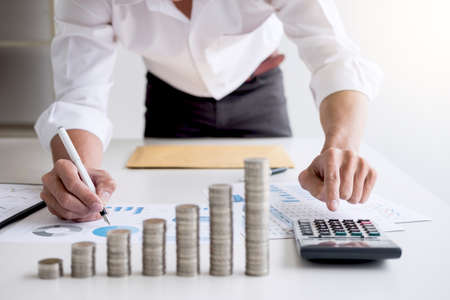 Business accountant or banker, businessman calculate and analysis with stock financial indices and putting growth stacking coin and financial costs wisely and carefully, investment and saving conceptの写真素材