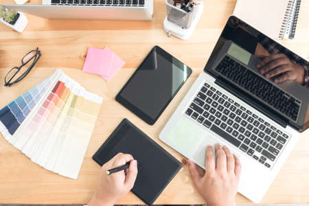 Architectural drawing with work tools, Graphic designer working with digital Drawing tablet and Pen on a computer and color swatches on a desk, interactive pen display, sketching at blank notepad,の写真素材