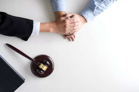 Image of Male lawyer or judge help encourage client, customer, working with gavel and Law books, report the case on table in modern office, Law and justice conceptの写真素材