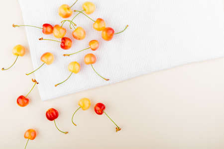 top view of cherries on white cloth and white background with copy spaceの写真素材