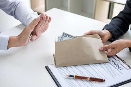 Bribery and corruption concept, Businessman refusing receive money in the envelope to agreement...