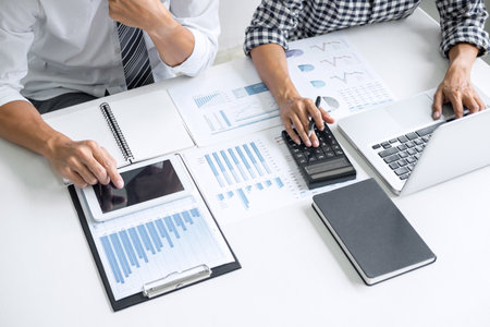 Teamwork of business casual colleagues, consultation new strategy plan business and market growth on financial document graph report, conference to making growth profit, Partner meetings and briefingの写真素材