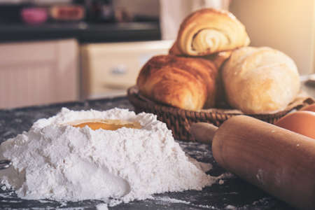 Raw dough for bread with ingredients on black background