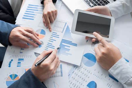 Business team hands at working with business plan and a tablet on office desk, Top view shot.