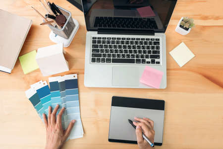 Architectural drawing with work tools, Graphic designer working with digital Drawing tablet and Pen on a computer and color swatches on a desk, interactive pen display, sketching at blank notepad,の写真素材