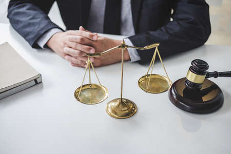 Male lawyer or judge working with contract papers, Law books and wooden gavel on table in courtroom, Justice lawyers at law firm, Law and Legal services conceptの写真素材