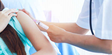 Female doctors are injecting the patient. Young patients are terrified of injections. concept of health careの写真素材