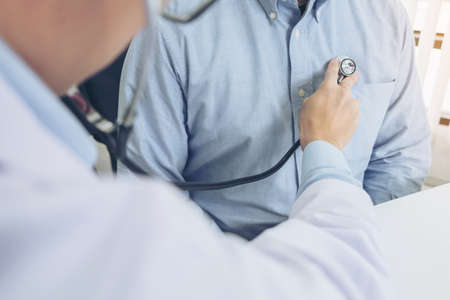 Close up of doctor listening to patient heartbeat with stethoscope on hospital, Physical examination, Medical and health care conceptの写真素材