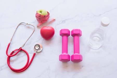 Dumbbell with red heart shape and green apple, healthy and fitness conceptの写真素材