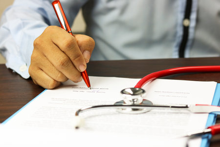 doctor writing prescription on deskの写真素材