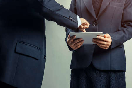 business people looking, consult and pointing at taplet about work makettingの写真素材