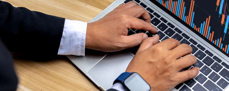 Close up hand of businessman trader trade stock and looking financial business graph data on laptopの写真素材