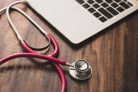 stethoscope with laptop of doctor on wood tableの写真素材