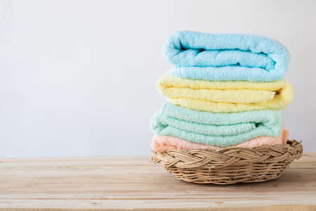 towel on basket on wood table with white wall and copy space, can be used for present productsの写真素材