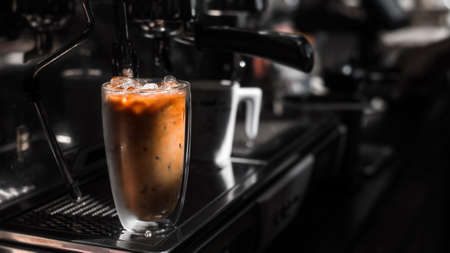 Close-up glass of iced coffee with milk on the tableの写真素材
