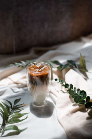 Close-up glass of iced coffee with milk on the table
