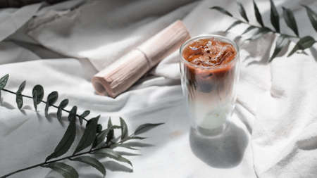 Close-up glass of iced coffee with milk on the tableの写真素材