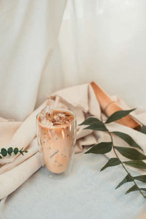 Close-up glass of iced coffee with milk on the tableの写真素材