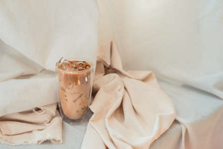 Close-up glass of iced coffee with milk on the tableの写真素材