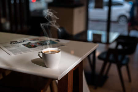 White coffee mug on the table inside the cafeの写真素材