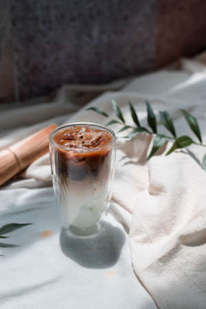 Close-up glass of iced coffee with milk on the tableの写真素材