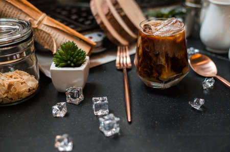 Close-up of iced coffee served on black table at cafeâの写真素材