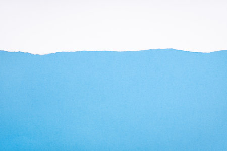 Ripped white paper on blue cardboard. Abstract paper background to add text or images. Copy space. Templateの写真素材