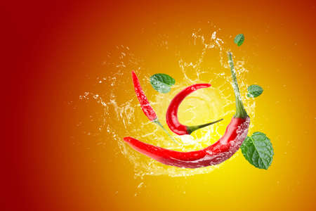 Water Splashing on red chili pepper on a red background.の写真素材