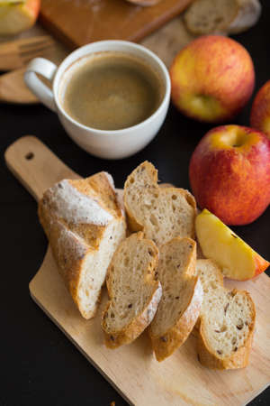 French bread baguette cut on wooden board with knife. with a chocolate butter