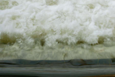 Motion blur of Powerful waves water with white foam rising upの写真素材