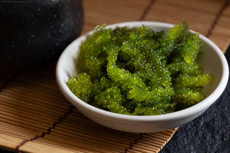 Oval sea grapes seaweed, Close up Green Caviar on dark backgroundの写真素材