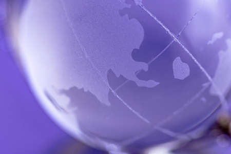 Globe is made of glass on a purple background. Glass globe. Globalization conceptの写真素材