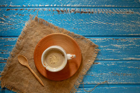 Cup of hot coffee in the morning on a blue rural wooden tableの写真素材