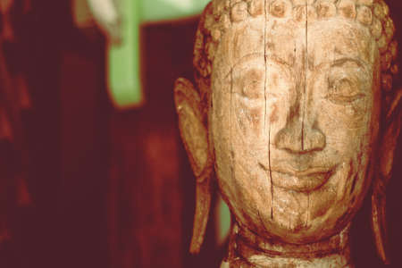 A wooden buddha head sculpture statue backgroundの写真素材