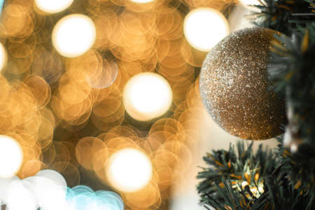 Selective focus Christmas tree with holidaygold ball and lights with copy space on blurred bokeh...