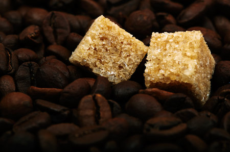 Coffee beans background with two brown sugar cubes. Natural morning light.の写真素材