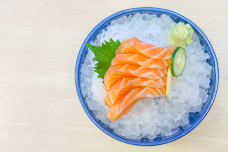 Salmon sashimi on ice serve with fresh wasabi and carrot slide, Japanese food style. Top view with copy space and textの写真素材