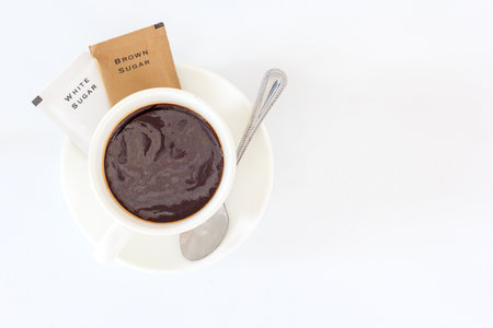 A cup of black coffee and sugar sachet for refreshing in the morning, Top view with copy space and text.の写真素材