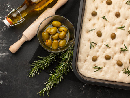 Top view focaccia dough with olivesの写真素材