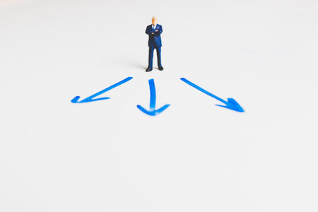 Miniature Businessman standing on arrow pathway , Business decision concept.の写真素材