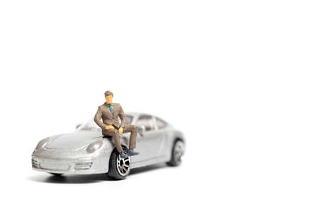 Miniature people business man sitting on a carの写真素材