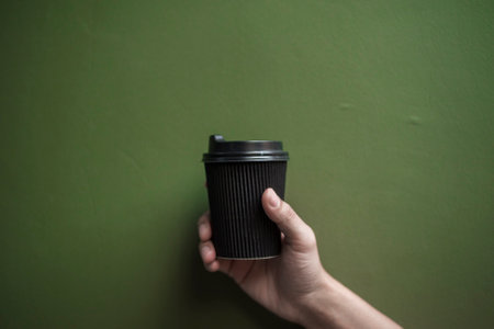Human hand holding coffee paper mug, Morning drinkの写真素材