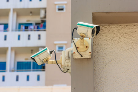 Security CCTV camera or surveillance system in office building on blue sky background