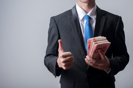 Business man holding China moneyの写真素材