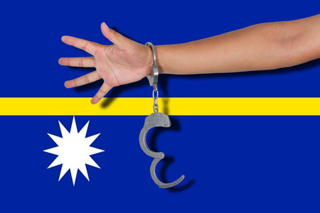 handcuffs with hand on Nauru flagの写真素材