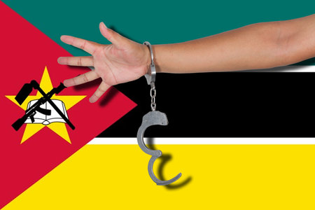 handcuffs with hand on Mozambique flagの写真素材