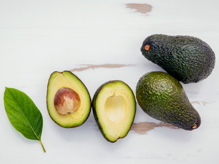 Healthy food concept . Close Up fresh avocado and leaves on white shabby wooden background. Food...