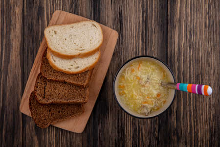 top view of breads as sliced rye and white ones on cutting board and bowl of chicken orzo soup with...